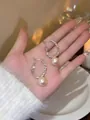 Close-up of French style silver hoop earrings with elegant hanging white pearls - Light Coffee Gold With Silver Pin