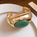 Nahaufnahme eines goldenen Armreifs im Vintage-Stil mit einem großen grünen Stein. - Grüner Aventurin Stil (HB5741) / Gold Grün