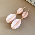 Detailed macro shot of elegant pink marbled acrylic drop earrings with gold bead accents - Earring Hooks / Pink