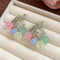 Dettaglio di orecchini a nappa con perle di resina colorata in un portagioie di velluto - Nappina Multicolore Tonda (Perno in Argento)