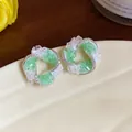 Close-up of elegant silver swirl stud earrings with green and white crushed crystals - Silver Earring Post - Silver - Green