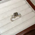 Macro view of vintage silver ring featuring a central heart-shaped smoky zircon gem. - Silver-Grey