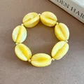 Macro detail of yellow marbled acrylic beads jewelry item with golden spacer beads - Bracelet / Yellow