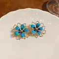 Eleganti orecchini a fiore in smalto blu con un raffinato design a contorno cavo dorato - Stile Fiore Traforato (HE32038) / Blu