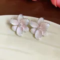 Nahaufnahme von eleganten rosa Emaille-Blumenohrsteckern mit funkelndem Zirkonia-Zentrum - Fünfblättrige Blume / 925 Silberstecker / Silber-Rosa