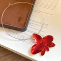 Dettaglio di una collana choker vintage con fiore in smalto rosso e strass luccicanti. - Collana choker / Rosso