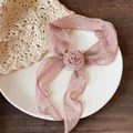 Detailed view of pink chiffon scarf featuring polka dots and central fabric rose flower - Pink