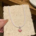 Macro detail of a sweet pink and red heart pendant necklace with elegant white pearls - White Heart Full Pearl Style (HN11430-4)