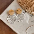 Detailed macro view of elegant round hollow lace earrings with gold studs on linen - Round / Gold