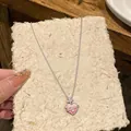 Close-up detail of a sweet pink enamel heart necklace with sparkling zircon star - Pink Heart Starburst Style (HN11430-5)