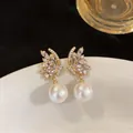 Elegant detail of luxury gold-plated butterfly earrings with sparkling zircons and pearls - Butterfly Shape (6081987309555)