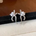 Detailed macro shot of elegant silver-tone bow earrings with pearl cluster accents - Bow Style / Silver