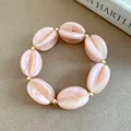 Chic pink marbled acrylic bead bracelet with gold accents on beige surface - Bracelet / Pink