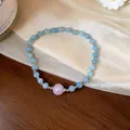 Gros plan d'un bracelet en perles d'aigue-marine naturelle avec une perle rose. - Bracelet Décor Perles Roses (7#)
