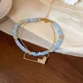 Gros plan d'un bracelet double rang avec perles bleues et pendentif cœur doré texturé - Bracelet Cœur Double Couche (3#)