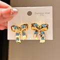 Close-up detail of vintage style gold bow earrings with blue turquoise flower inlays - Bow Flower Style (4#)