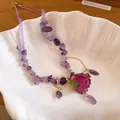 Detail shot of a handmade amethyst stone necklace with a dried rose flower pendant - Purple