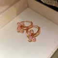 Gros plan de boucles d'oreilles créoles fleurs plaquées or 14 carats avec zircon. - Style Floral (HE33444) / Or rose