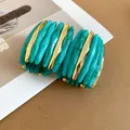 Dettaglio ravvicinato del bracciale di lusso con acrilico verde acqua marmorizzato e coste dorate - Verde