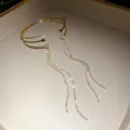 Vista dettagliata di un elegante bracciale dorato a doppio strato con nappe di strass - Stile Aperto Doppio Strato Nappa / Oro