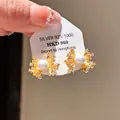 Elegant gold flower stud earrings with white pearl and zircon accents on display card - Radial Flower Pearl Style (41#)