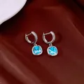Détail de boucles d'oreilles en argent avec zircons carrés bleus et anneaux pavés - Boucle d'oreille / Bleu
