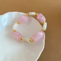 Elegant pink and white acrylic oval beaded bracelet featuring stylish gold-tone spacers - Bracelet / Pink