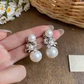 Detailed close-up view of French style pearl ear clips with sparkling zircon firework design - Silver-White