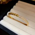 Gros plan d'un bracelet jonc plaqué or 18 carats avec perles et pavé de zircons - Style Perles et Pavé (HB5586)