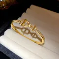 Gros plan sur un jonc élégant plaqué or 18 carats avec maillons évidés en zircone - Double Loop Hollow CD Style (HB5581)