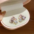 Close-up view of elegant geometric waterdrop cubic zirconia earrings in a pink gift box. - Pink