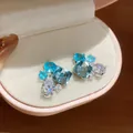 Close-up of elegant geometric teardrop stud earrings with blue sparkling cubic zirconia - Blue