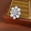 Primo piano di un anello regolabile placcato oro 14k con design floreale in zirconi - Forma Floreale (HR3593) / Argento