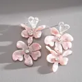 Dettaglio di orecchini a fiore in resina rosa marmorizzata con cuori e piccoli cristalli. - Stile Nappina Fiore Cuore / Rosa