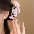 Detailed close-up of a delicate pink flower hair pin worn in a graceful updo hairstyle. - Pink Style (HH9871) / 1 Piece / Pink