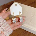 Detailed view of French-style gold hoop earrings with white zircon flower pendant charm - Flower Ear Hook Style / Gold/White