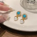 Detailed close-up of vintage gold earrings featuring turquoise blue stones and pearls - Round Rhinestone Pearl Drop Style (HE32849)