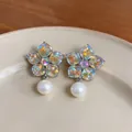 Close-up of elegant flower-shaped earrings with colorful crystals and pearls. - Flower Pearl Stud Earrings (HE32601) / Silver And Multicolor