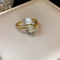 Primo piano di un elegante anello placcato oro 14k con perla e accenti di zirconi brillanti. - Stile 1 Anello Perla Zirconia