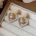 Close-up detail of romantic 14k gold plated flower heart earrings with pearls and strawberries - Gold-Pink