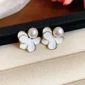 Close-up of 18k gold plated flower earrings with elegant white pearls and enamel details - Silver Earring Post Style / Gold-White