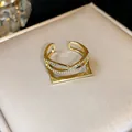 Primo piano di anello placcato oro 14k con fascia incrociata in zirconi e base - Stile 4 Anello Zirconia Doppio Strato