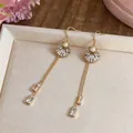 Elegant long gold tassel earrings with shell design, white crystals and pearls - Ear Hook Shell Style / Gold
