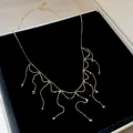 Detailed view of a gold-toned fringe necklace with elegant bead accents. - Gold