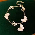 Elegantes vergoldetes Schmetterlingsarmband mit rosa Muscheleinlagen und Zirkonsteinen - Schmetterling Design / Gold-Rosa