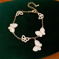 Elegantes goldenes Schmetterlings-Armband mit funkelnden Zirkonia-Steinen auf grünem Samt. - Schmetterling Design / Gold-Weiß