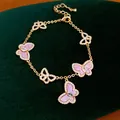 Elegantes Goldkettenarmband mit funkelnden Zirkonia und rosa Schmetterlingsanhängern - Schmetterling Design / Gold-Lila