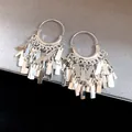 Macro view of silver geometric metallic tassel earrings with rectangle pendant details - Silver