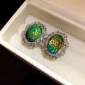 Dettaglio di orecchini vintage in resina verde con alone di strass brillanti - Ovale / Verde
