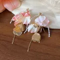 Close-up of elegant acrylic flower petal earrings with golden leaf charms and beaded strands - Flower Petal Tassel Long Style / Pink And Gold (HE31613)